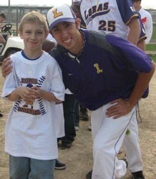 coach poses with young baseball player